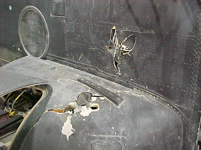 Damage to electrical pod by RPG, right side near cockpit.