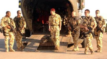 Britain's Prince Charles is under heavy guard, as he leaves a Chinook helicopter at Basra Airport, Iraq, on Sunday, 8 February 2004. The Prince flew into the British Army controlled city to see for himself the progress of British forces in partnership with locals, nearly one year after the second Gulf War started.